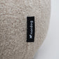 Beige cushion with a black label on a white background