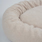 Beige pet bed with a soft texture on a light gray background